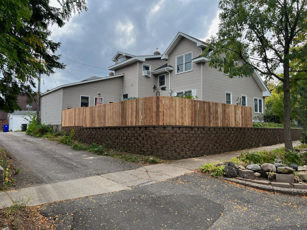 Tan vinyl privacy fence along a tree-lined backyard in Coon Rapids, MN
