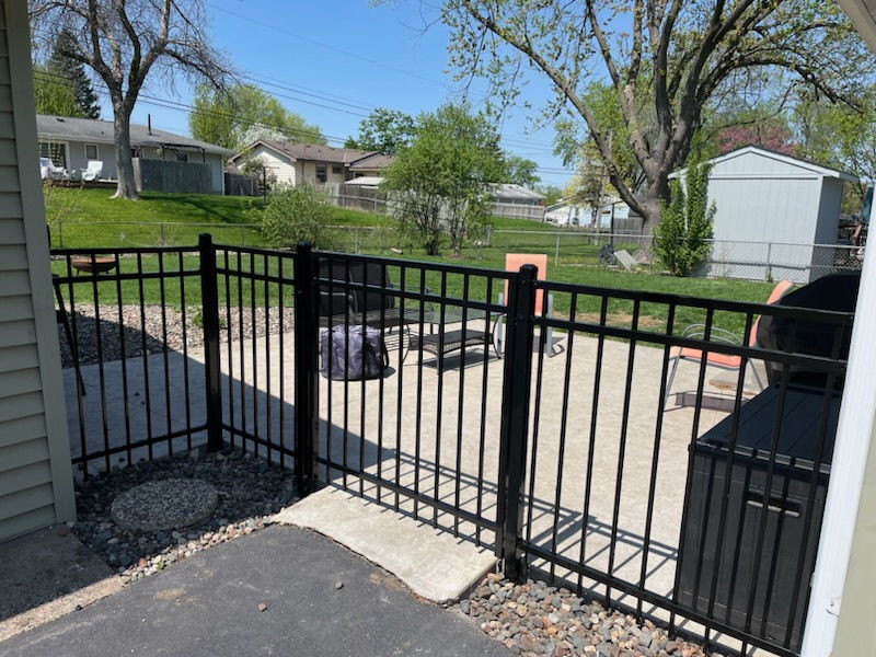 Black aluminum ornamental fence installed along a driveway in Maple Grove, MN